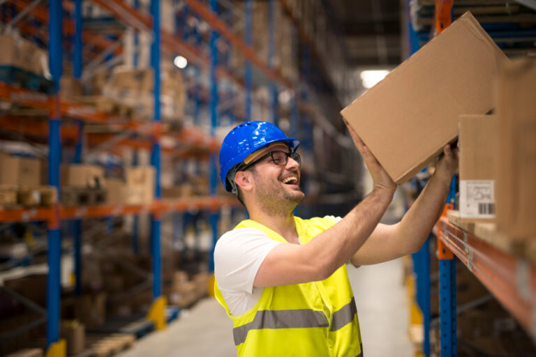 smiling-warehouse-worker-moving-boxes-shelf